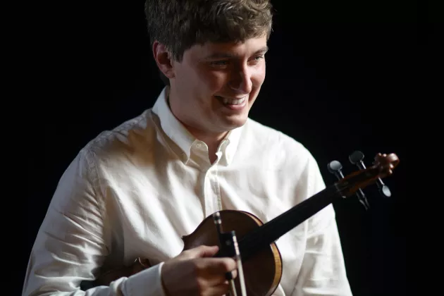 Marcus Bäckerud ler och och står med violinen under armen i sin vita skjorta