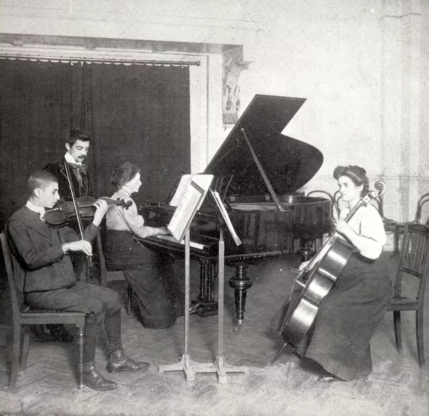 Musiklektion ledd av direktör Giovanni Tronchi (stående) år 1909. Foto.